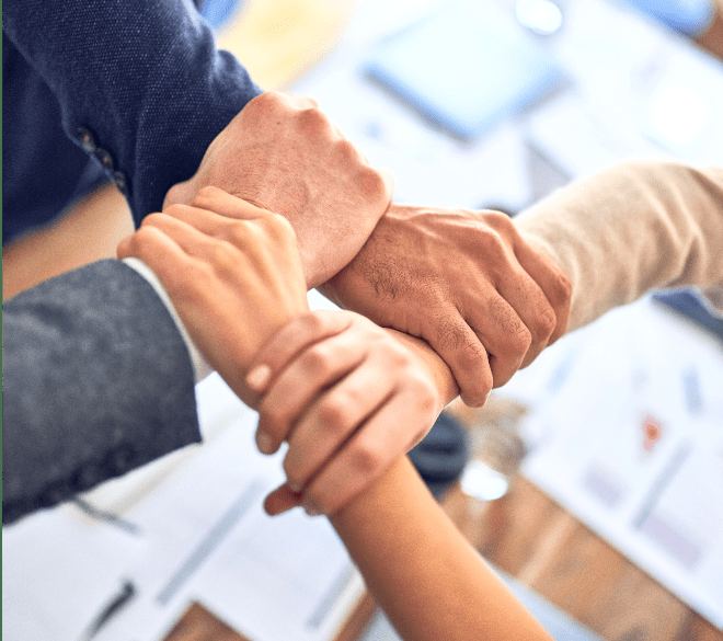Colleagues linking arms across a table
